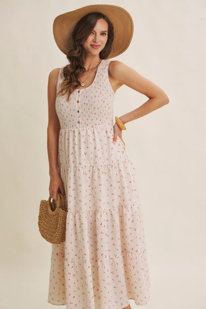 Cherry gingham print maxi dress in the color biscuit. The dress has a smocked bust, round neck, button-down detail, side pockets and comes lined. 