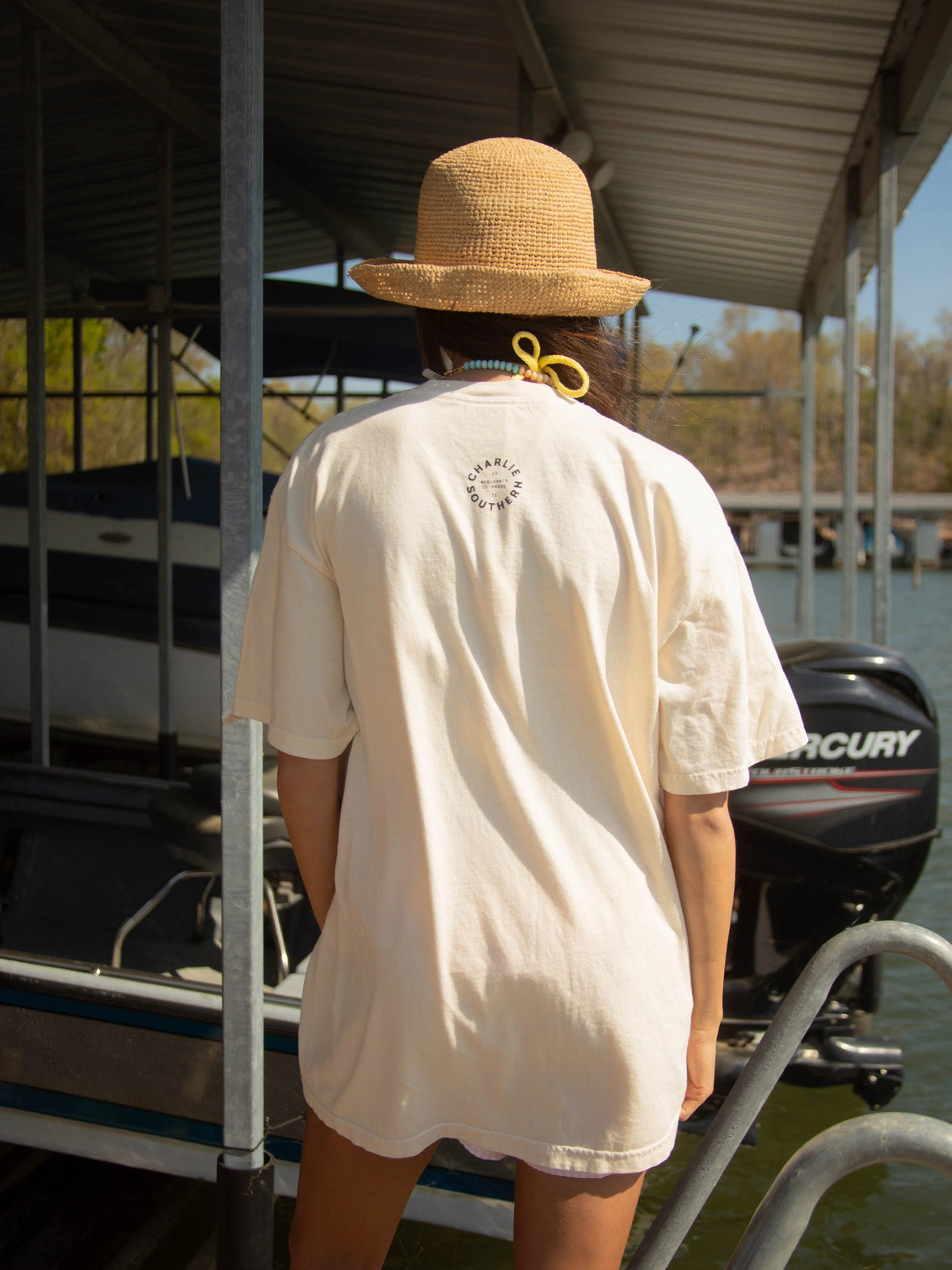 A women's oversized relaxed-fit cream graphic t-shirt featuring three stacked fish illustrations in shades of coral, pink, and red with the phrase "What A Catch" printed in the bottom right corner.