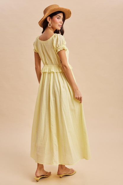 Maxi Dress in Lemon Water Yellow is a lightweight, feminine yellow maxi dress featuring delicate Swiss dot fabric, puff sleeves, and a flattering button-front bodice