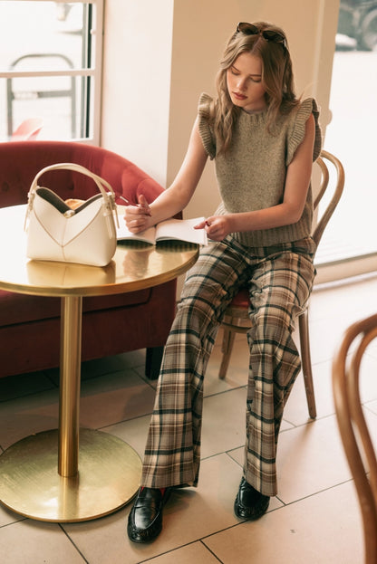 A women's high-waisted wide-leg plaid trousers in black and warm brown featuring front pleats, belt loops, and a relaxed straight drape.