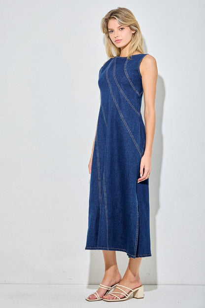 Sleeveless dark denim dress with angle detailing and a side slit. 