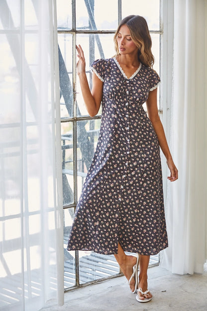 A women's short flutter sleeve midi dress in antique black featuring a pink vintage rose floral print, white scalloped lace trim along the V-neckline, and a full button-down front.