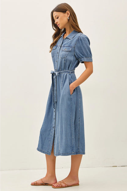 A women's short puff-sleeve denim shirt dress in a light wash featuring a pointed collar, a full button-down front, a matching waist tie belt, and convenient side pockets.