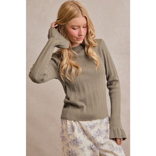 A women's olive green long-sleeve cable-knit sweater featuring a mock neckline, ribbed hem, and ruffled flare knit cuffs.