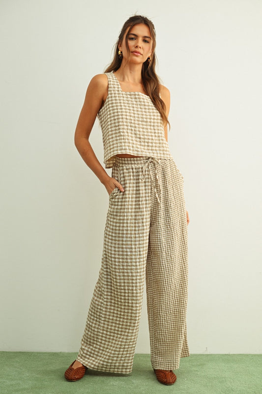 Tan and cream mixed gingham print pants featuring a high-rise elastic drawstring waistband, a relaxed straight-leg silhouette, and a lightweight textured fabric.