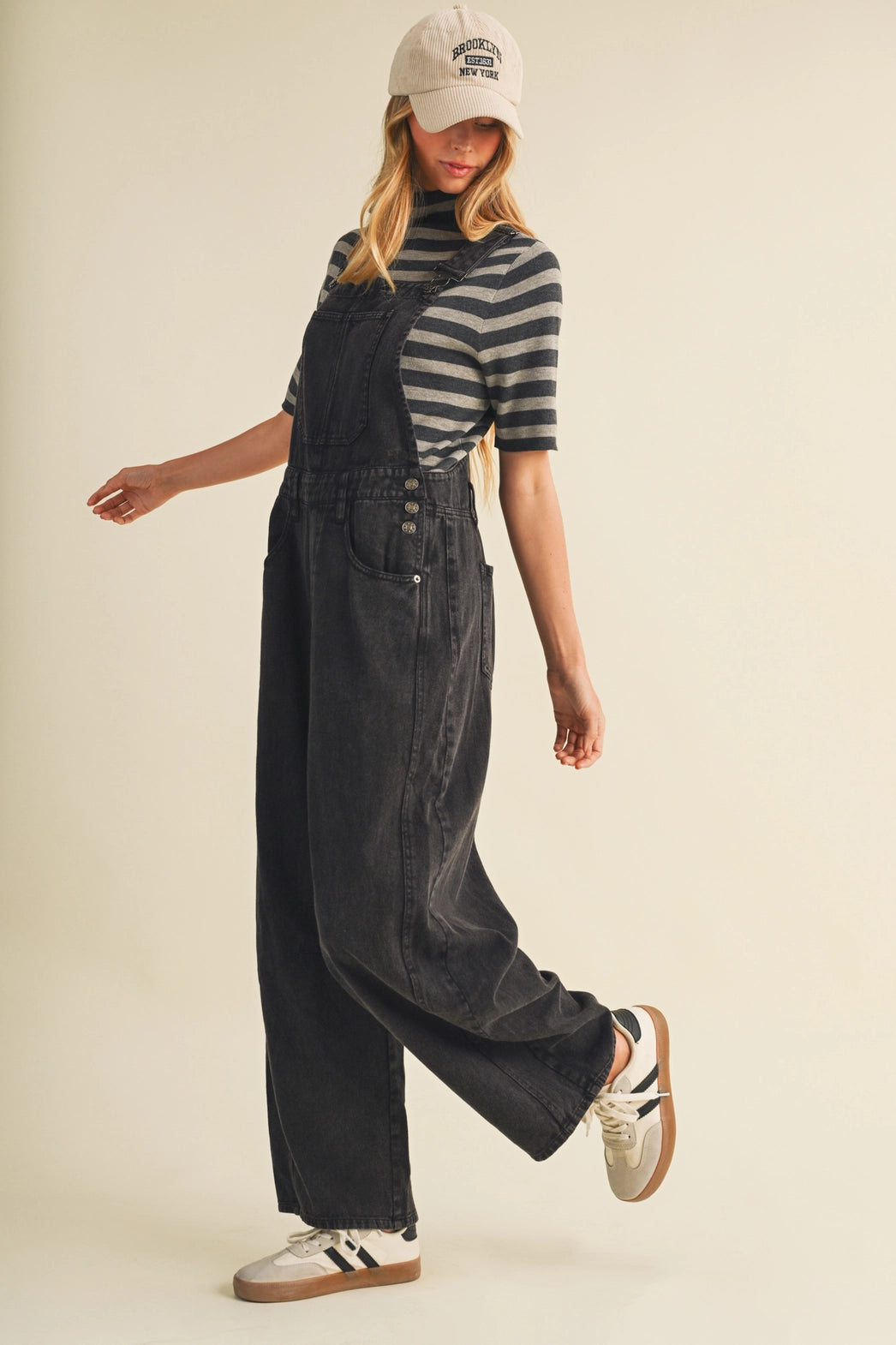 A pair of women's high-waisted wide-leg twill overalls in a vintage washed black denim finish featuring classic adjustable shoulder straps, a front chest pocket, and side pockets.