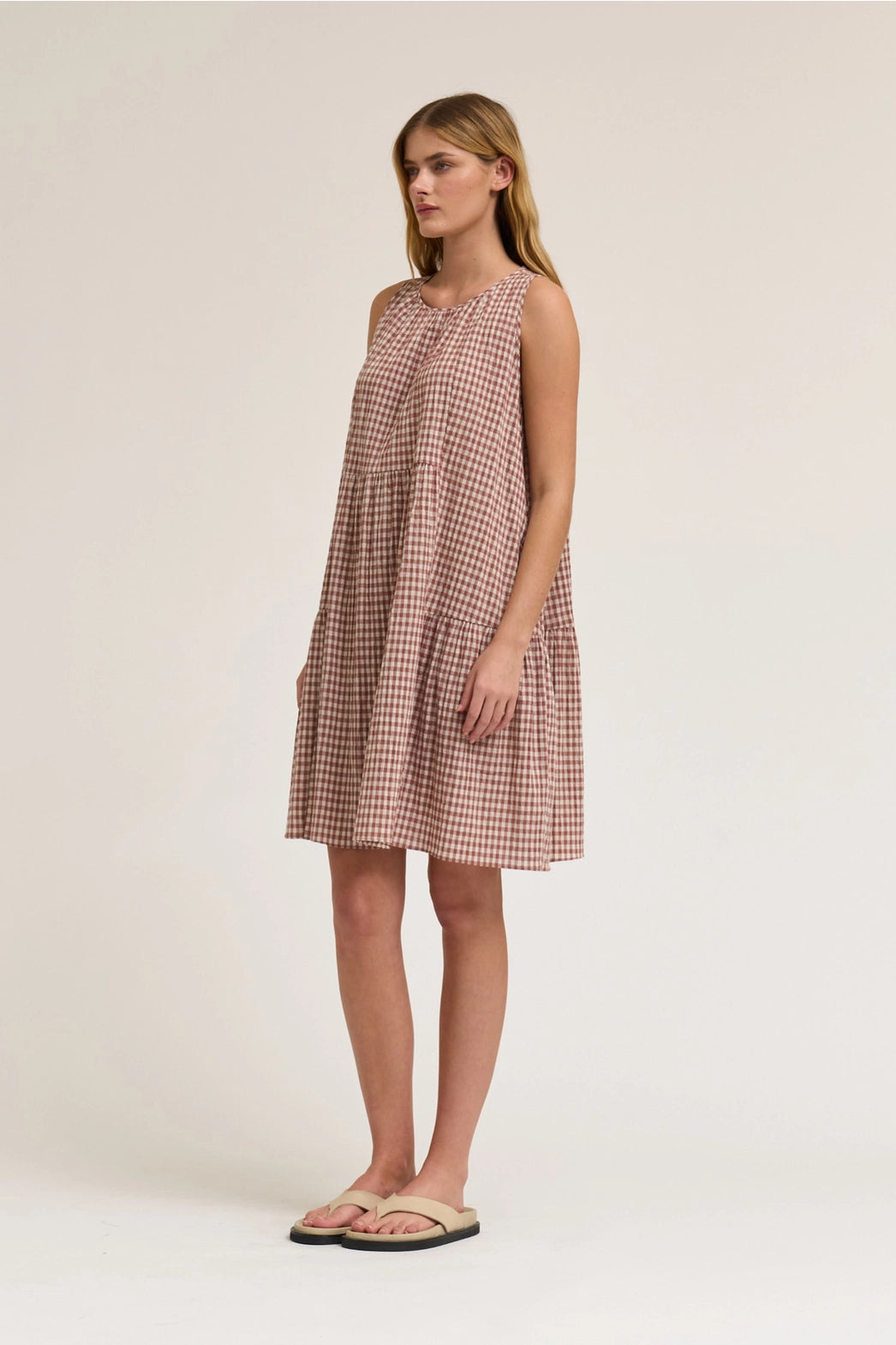 Sleeveless Gingham mini dress in dusty rose. With a round neck and a tie in the back. 