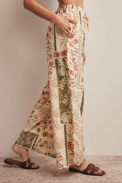 High-waisted wide-leg patchwork floral print pants in ecru, terracotta, and olive green featuring a comfortable elastic drawstring waistband and a relaxed silhouette.