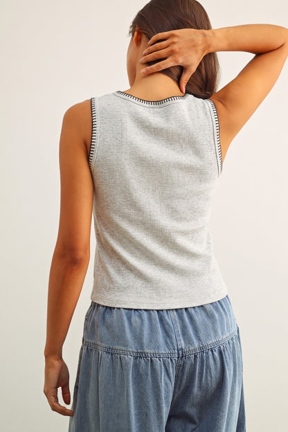 A women's sleeveless crewneck ribbed knit tank top in heather gray featuring a contrasting black blanket-stitch detail along the neckline and armholes.