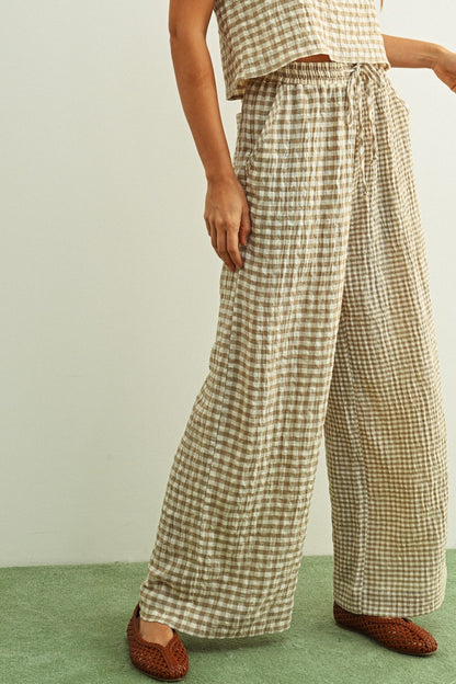 Tan and cream mixed gingham print pants featuring a high-rise elastic drawstring waistband, a relaxed straight-leg silhouette, and a lightweight textured fabric.