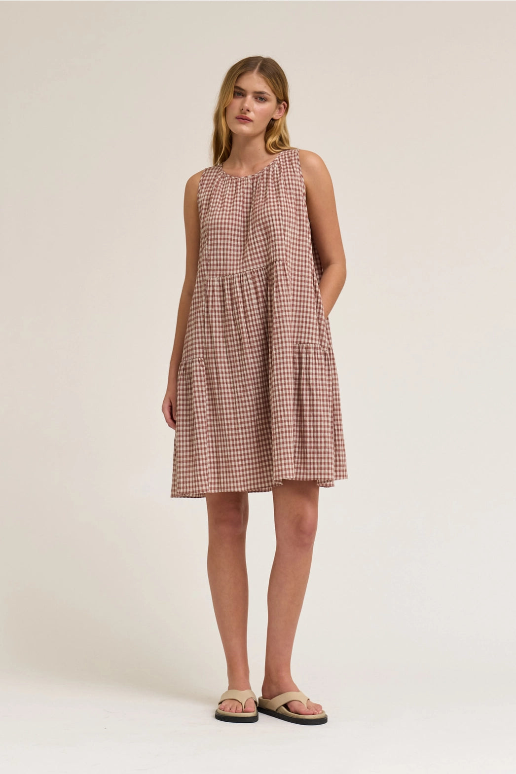 Sleeveless Gingham mini dress in dusty rose. With a round neck and a tie in the back. 
