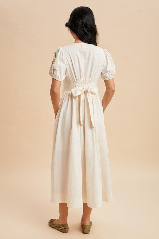 Embroidered Button-Up Midi Dress in Buttercream. 
Small puff sleeve.
Chest and sleeve contain floral embroidered details
Smocked waist