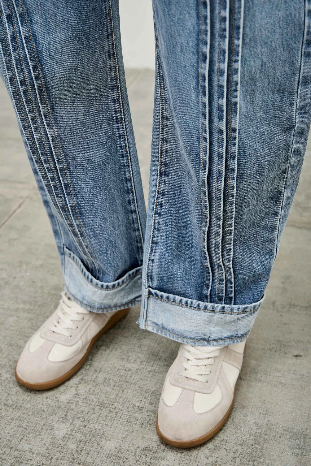 Medium wash barrel denim jeans. 
Button and zipper closure 
Front pleated details
False front cuff detail
