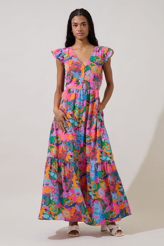 A fuchsia multi-color floral maxi dress featuring a V-neckline, functional button-down front, tiered skirt, flutter sleeves, and hidden side pockets.