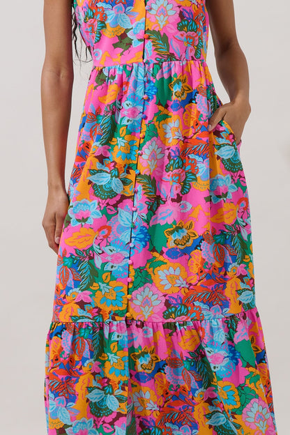 A fuchsia multi-color floral maxi dress featuring a V-neckline, functional button-down front, tiered skirt, flutter sleeves, and hidden side pockets.