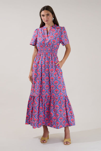 A women's short-sleeve maxi dress featuring an all-over damask floral print in cerulean red with an elastic smocked waistband, a split neck collar, and a tiered ruffle skirt.