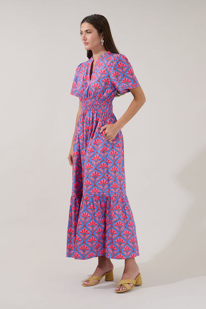 A women's short-sleeve maxi dress featuring an all-over damask floral print in cerulean red with an elastic smocked waistband, a split neck collar, and a tiered ruffle skirt.